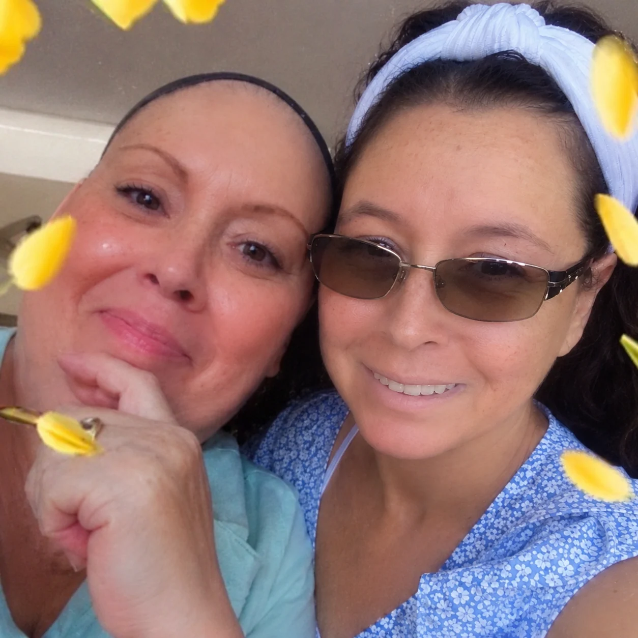Two sisters smiling together in a close-up portrait